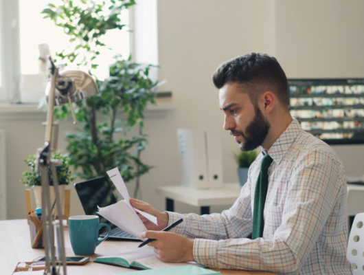 Business person reading document at desk