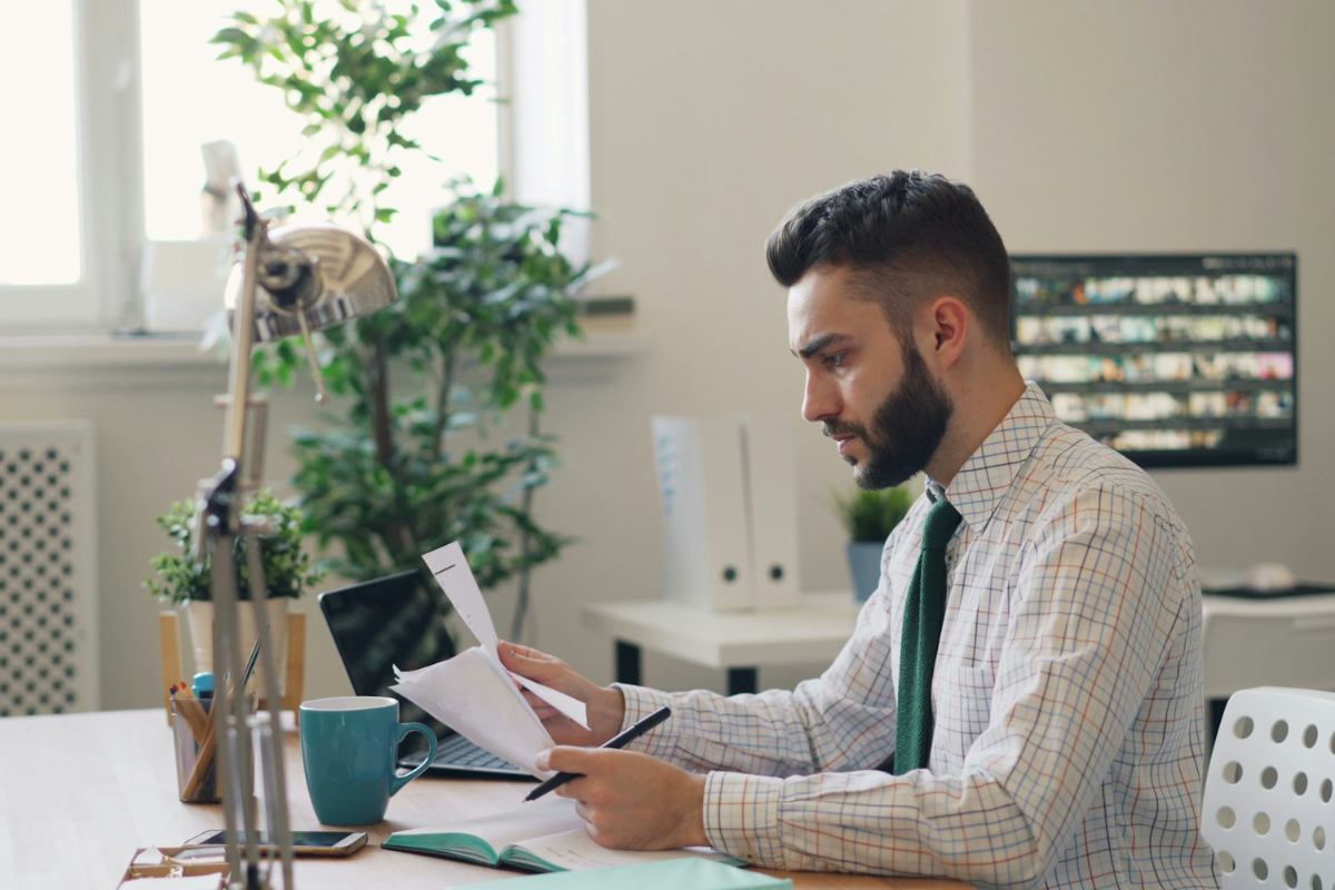 Business person reading document at desk